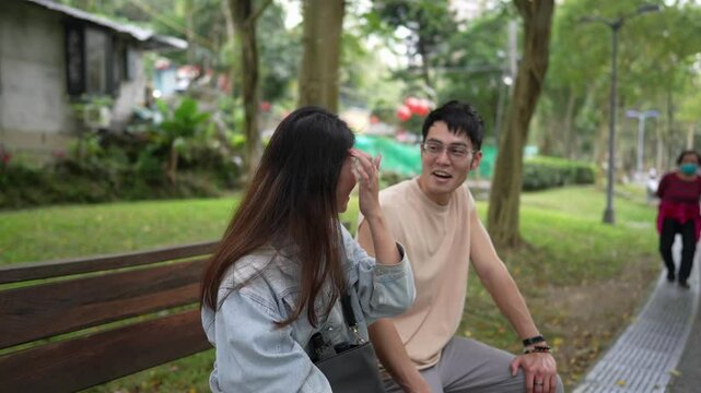 Slow-motion video of a young Taiwanese couple in their 20s sitting and talking intimately on a park bench in Xinyi District, Taipei, Taiwan
台湾台北市信義区の公園のベンチで20代の台湾人カップルが座って仲良く話しているスローモーション動画
