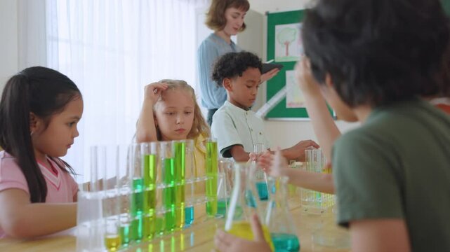 Adorable student learn with teacher in classroom at elementary school.
