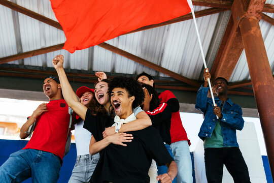 Ecstatic sports fans celebrating with flag