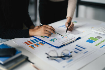 Business Team Analyzing Financial Data and Graphs on Office Desk with Documents and Charts