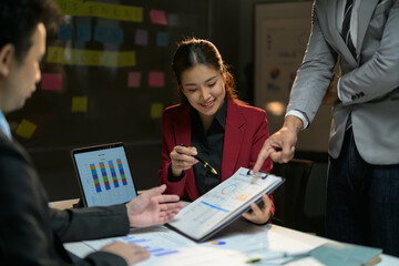 Business Team Collaborating on Project in Modern Office with Charts and Graphs