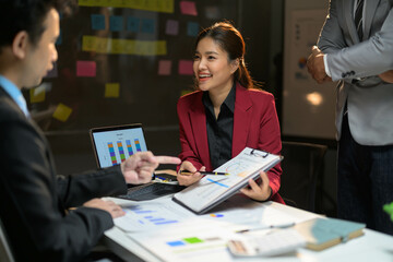 Business Meeting with Diverse Team Discussing Charts and Graphs in Modern Office Setting