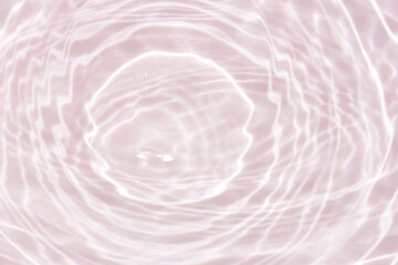 Pink water bubbles on the surface ripples. Defocus blurred transparent pink colored clear calm water surface texture with splash and bubbles. Water waves with shining pattern texture background