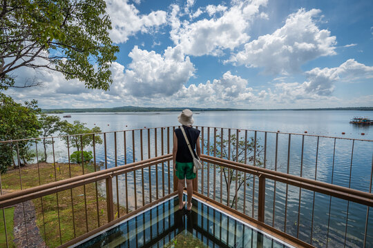 The young girl in the transparent glass skywalk in Sirindhorn Dam at Ubon Ratchathani, Thailand