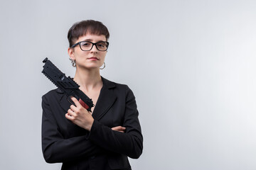 Businesswoman holding gun posing on white background