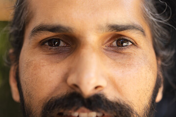 Close-up of Indian male face with beard and mustache, looking directly ahead