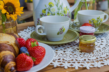 Morning summer tea with flowers and fruits on the veranda in the village house