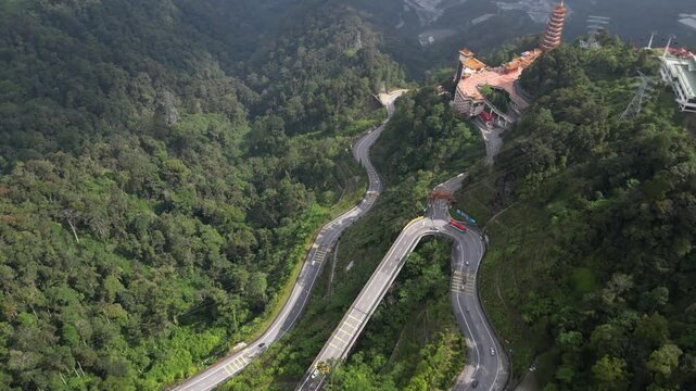 Aerial pan shot of Genting highlands surrounded by greenery and Chin Swee caves temple in Malaysia.