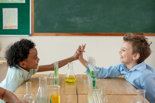 Adorable student learn with teacher in classroom at elementary school.