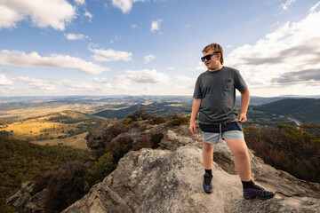Boy standing on rock at Hassans Walls Lookout watching valley below