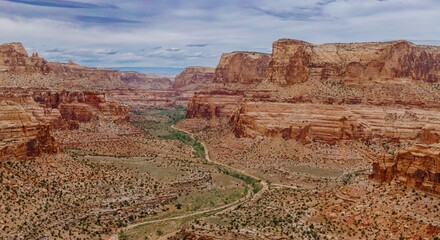 Fototapeta premium Dirt road going through a Canyon and tall Buttes. Buckhorn Wash, Utah, United States of America.