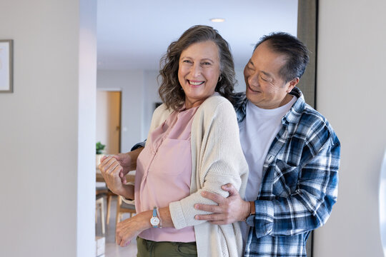 Senior couple hugging and smiling, enjoying quality time together at home