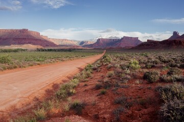 Desert dirt road, Buttes and mesa in the desert, Moab, Utah, United States of America.