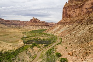 San Rafael river, grassland and camping ground in the desert and tall buttes. Buckhorn Wash, Utah, United States of America.