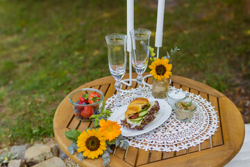 Summer table with wine and snacks fruit and croissants rustic landscape