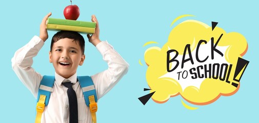 Little schoolboy with apple and books and text BACK TO SCHOOL on light blue background