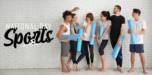 Obraz premium Group of sporty people with yoga mats near white brick wall