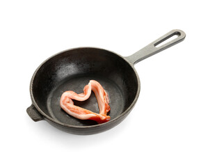 Frying pan with heart made of tasty bacon on white background
