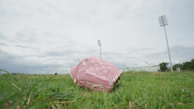 Pink baseball grove , pink softball glove In the middle of the green grass field, there was a moving sky.for World Breast Cancer Day,Time Lapse