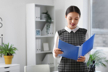 Portrait of Asian businesswoman with folder in office