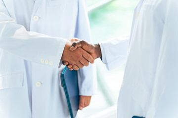 ロビーで握手する白衣の多国籍グループ