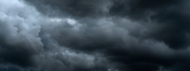 Fototapeta premium Banner Dramatic dark storm clouds black sky background. Dark thunderstorm clouds rainny season. Panorama Meteorology danger windstorm disasters climate. Dark cloudscape storm cloud with copy space.