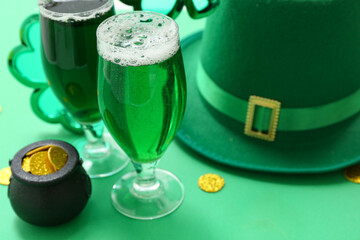 Glasses of beer with coins and leprechaun hat on green background. St. Patrick's Day celebration