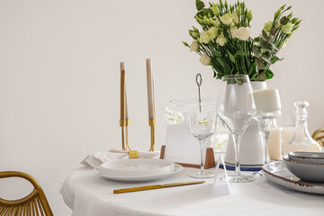 Beautiful table setting with white flowers and candles for wedding celebration in room