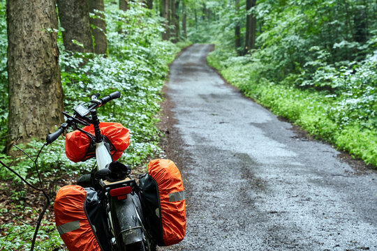 Heavy Touring Bike Equipped with Rain Cover on a Ride Through a Dense Forest in Czechia During a Cycling Trip