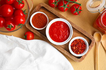 Bowl of tomato sauce and spices on brown background