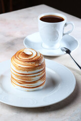 Sweet marshmallows or meringue with a honey layer. Dessert on a white plate with a cup of coffee. The concept of food and drinks.