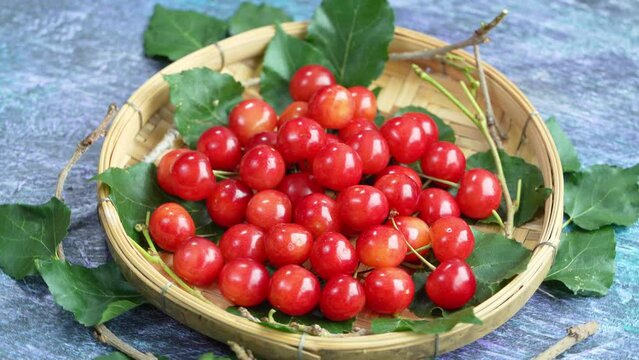Red Cherry fruit in bamboo basket on on wooden background, Japanese Red highest variety of cherries on wooden table in the garden.