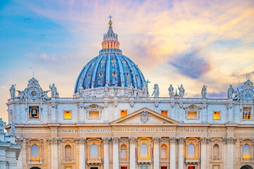 Obraz premium A scenic view of the iconic dome of St. Peters Basilica in Vatican City at sunset. The buildings facade and dome are illuminated by the warm glow of the evening light.