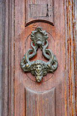 Old metal knocker on wooden door