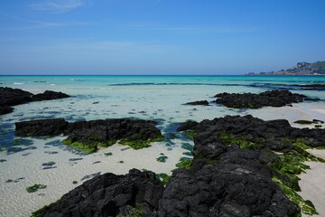 clear rock beach and far island