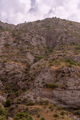 A mountain with a rocky terrain and a few trees