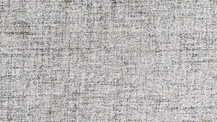 Close-up of textured gray fabric with subtle flecks of white and black. Ideal for backgrounds, textures, or design elements