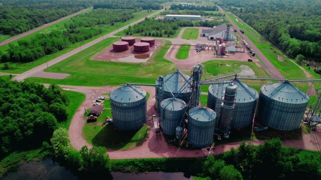 Sliding aerial country side at gain elevator where semi truck driver with hopper trailer loads with corn. Wisconsin Rapids, WI, USA