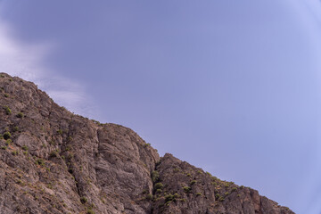 A mountain with a blue sky in the background