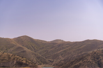 Fototapeta premium The sky is clear and the mountains are covered in green grass