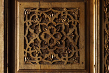 Old wooden decoration on an old door with carved Arabic pattern