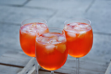 three aperol glasses on a table