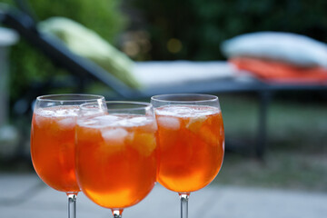three aperol glasses outside in the garden, relaxing summer time