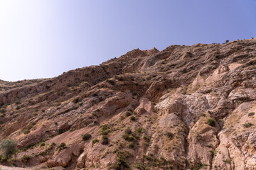 A rocky hillside with a clear blue sky in the background