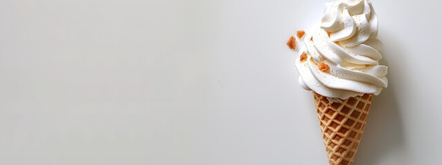 A pristine ice cream cone, adorned with white icing and vibrant orange sprinkles, waits on a pristine white surface for delightful consumption (4