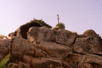 A rocky hillside with a power line running through it