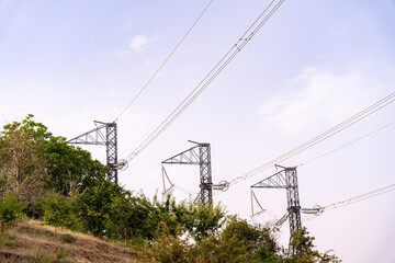 Three tall power lines are seen in the sky, with a few trees in the background