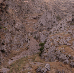 A rocky hillside with a small stream running through it