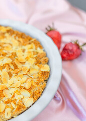 healthy desserts on plate on modern kitchen counter on plate.crumble with strawberry and almond, chocolate brownie pie and cupcakes with cranberries.vase with flowers as decor,woven placemat