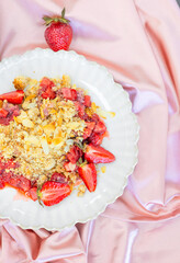 healthy desserts on plate on modern kitchen counter on plate.crumble with strawberry and almond, chocolate brownie pie and cupcakes with cranberries.vase with flowers as decor,woven placemat